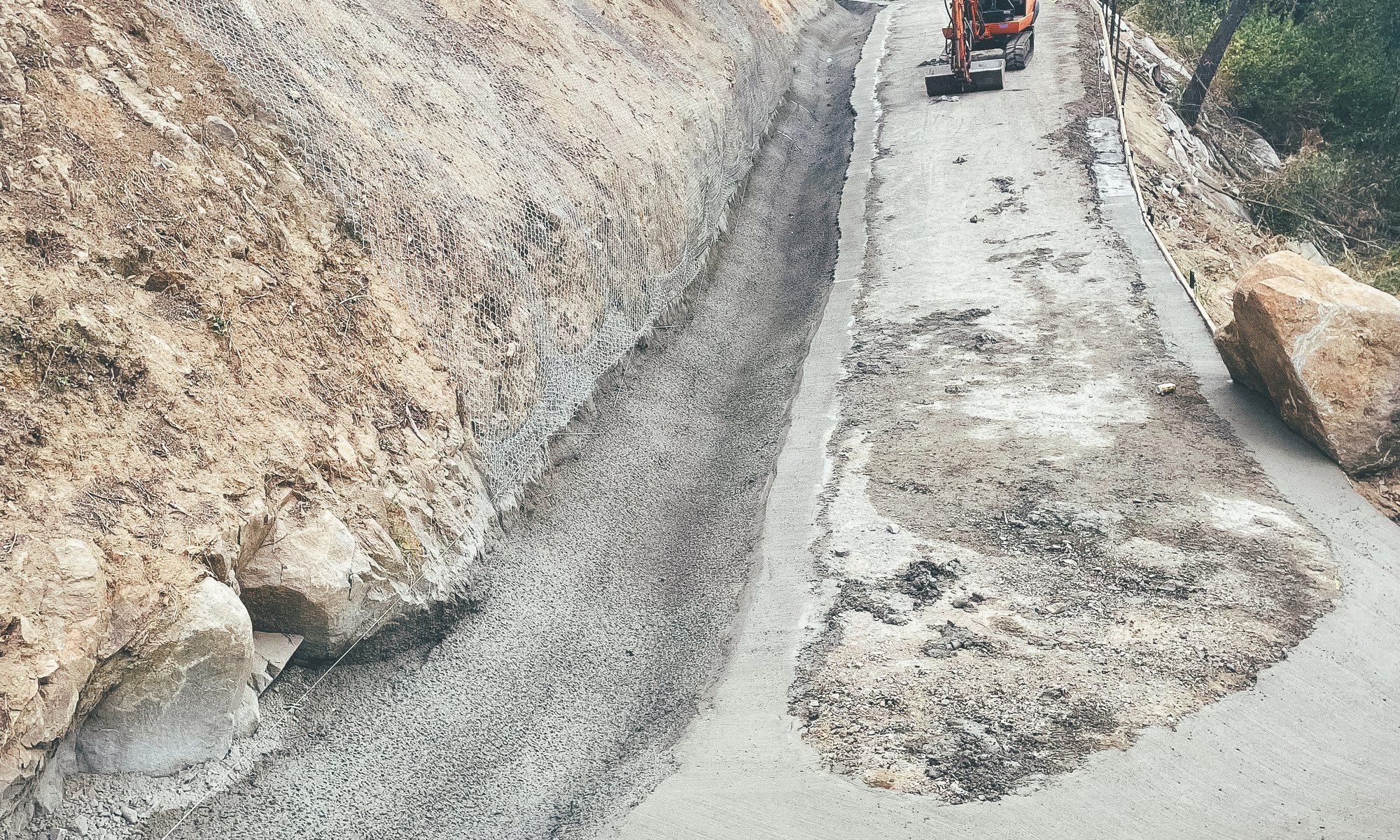 A sprayed batter and drainage line running down a steep civil site