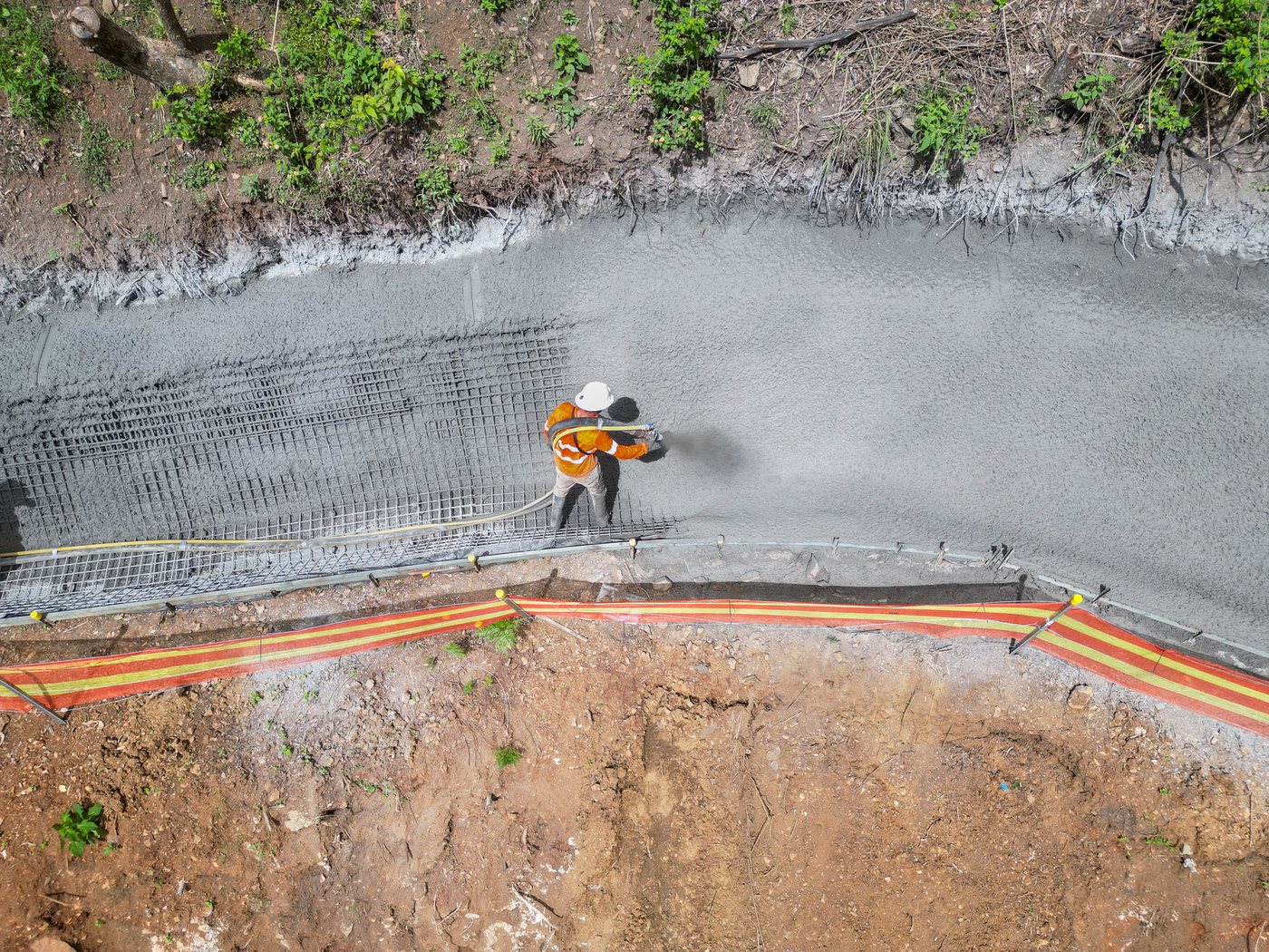 An aerial view of a pool shell being sprayed over mesh