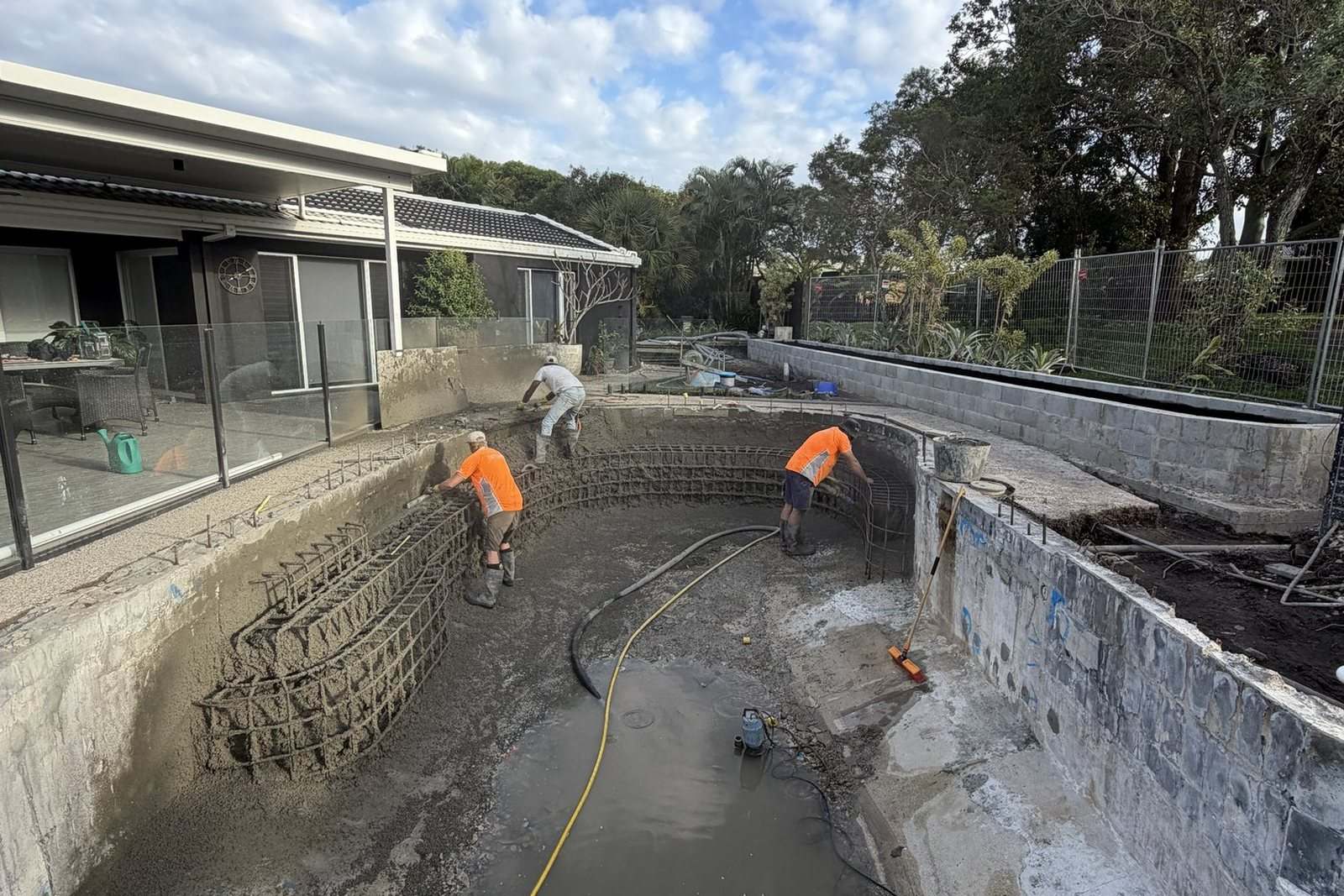 The Pumpd crew spraying shotcrete into a pool shell on a residential renovation